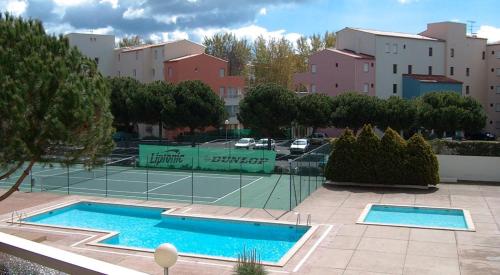 un court de tennis à côté d'un court de tennis dans l'établissement NAUTICAP Joli T2 alcôve piscine tennis NAUTICAP Plage Richelieu cap d'Agde, au Cap d'Agde