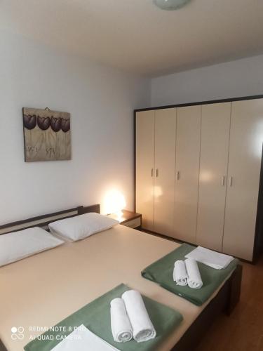 een slaapkamer met een bed met handdoeken erop bij Apartments Višnja in Pag