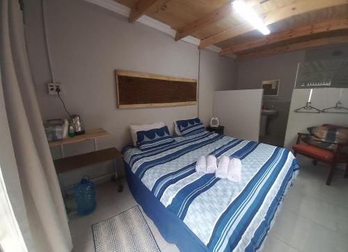 een slaapkamer met een groot bed met blauwe en witte lakens bij Sugarbush & Burgundy in Zeerust