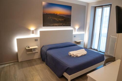 1 dormitorio con 1 cama con sábanas azules y una pintura en la pared en Agriturismo "Le Giustizie", en Agliano Terme