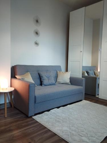 a living room with a blue couch and a rug at Életvirág Rezidencia és Vendéglak in Egerszalók