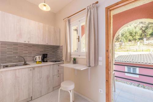 une cuisine avec un évier et une fenêtre dans l'établissement Studio Apartments with large swimming pool and Sea view at Pelekas Beach Corfu, à Pelekas