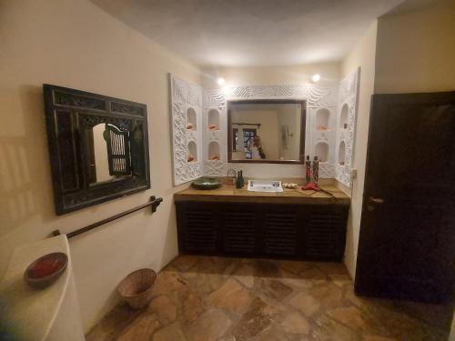 a bathroom with a sink and a mirror at Gulu House in Malindi