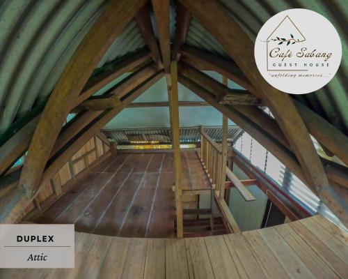 an attic with a wooden floor with the words oak strategy east fork at Cafe Sabang Guest House in Sabang