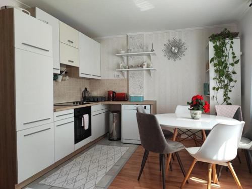 a kitchen with white cabinets and a table and chairs at Apartments Bionda - seafront in Zaboric