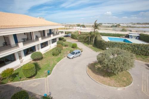 een auto geparkeerd op de oprit van een huis bij Baraka Apartments in Scoglitti