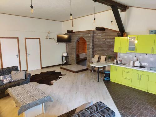 sala de estar con armarios verdes y cocina en Atpūtas komplekss Burtakas, en Straupe