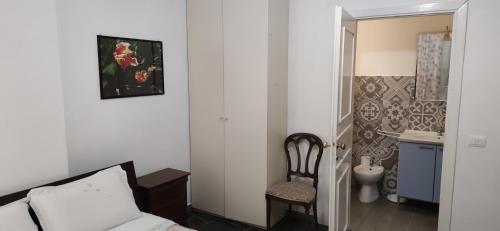 sypialnia z łóżkiem i krzesłem oraz łazienka w obiekcie La Badia del Cavaliere 1 w Rzymie