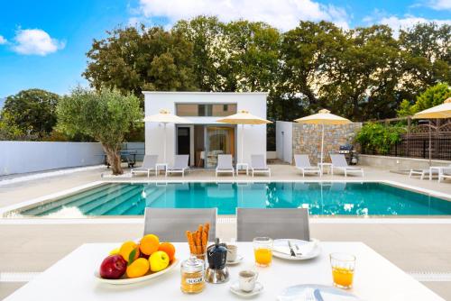 a villa with a pool and a table with fruit on it at Ialyssos Charme Villa in Ialyssos