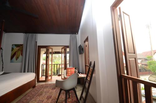 a bedroom with a bed and a desk with a chair at Moonlight Champa Riverview in Luang Prabang