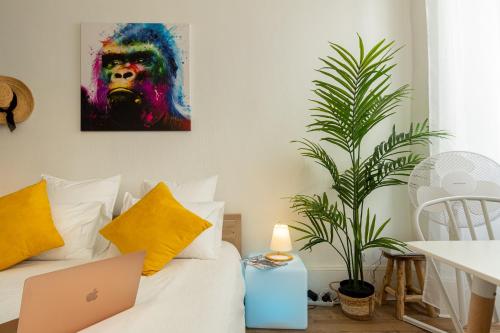 a room with a laptop on a bed with a plant at VilleneuveCityStay Jungle in Villeneuve-sur-Lot