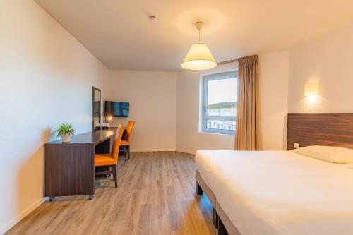 Una cama o camas en una habitación de Appart'City Classic Genève - Gaillard