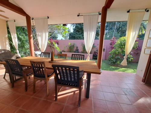 a dining room with a wooden table and chairs at Laura's Guest House-adult only- in Lamai