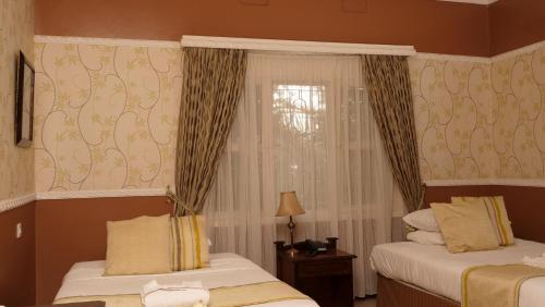 a hotel room with two beds and a window at The Clarice House in Kisumu