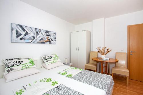 una camera da letto bianca con un letto e un tavolo di Villa Bianca a Trogir