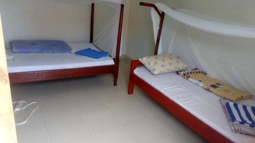 Fort Portal的住宿－Knowledge For Change House，一间客房内配有两张床的房间
