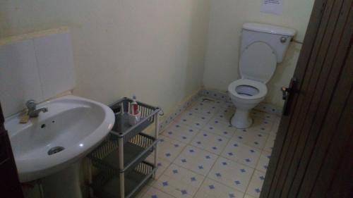 ein Bad mit einem Waschbecken und einem WC in der Unterkunft Knowledge For Change House in Fort Portal