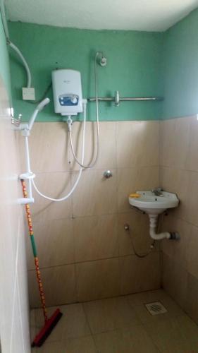een badkamer met een douche en een wastafel bij Knowledge For Change House in Fort Portal