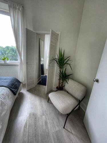 a bedroom with a bed and a chair and mirrors at 1 Bed Apartment (sleeps 4) on Leith Walk in Edinburgh
