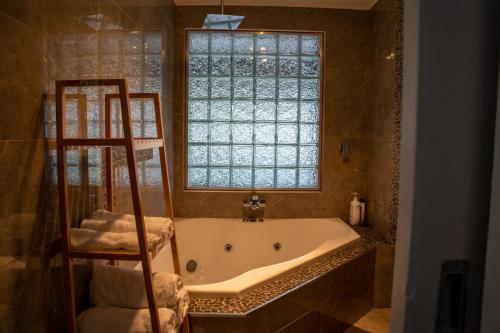 uma banheira na casa de banho com uma janela em Cosy 4 Bedroom Holiday Home - Melbourne Airport em Greenvale