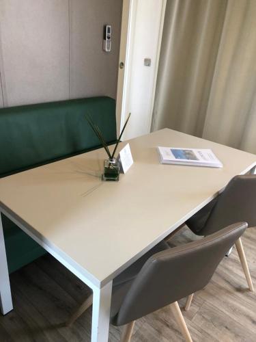 a white table and chairs with a laptop on it at Green Village - Sirenetta in Savigliano