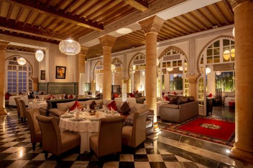 a restaurant with tables and chairs in a large room at La Tour Hassan Palace in Rabat