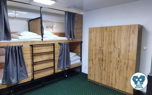 a room with two bunk beds and wooden cabinets at Место встречи "Guest House Meeting place" in Bishkek