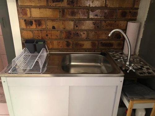 a kitchen with a sink and a brick wall at K4T guest unit in Groblersdal