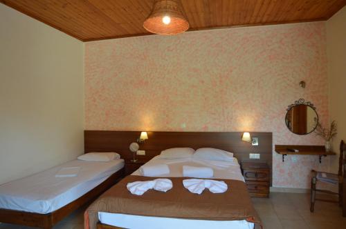 Cette chambre comprend 2 lits et un miroir. dans l'établissement Mr. Greek Villa, à Petra