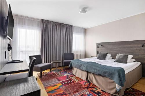 ムータラにあるBest Western Motala Stadshotellのベッドとデスクが備わるホテルルームです。