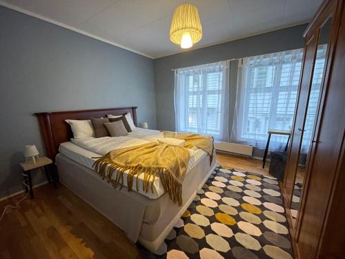 Un dormitorio con una cama con una manta amarilla. en Brand-New 2bd Apt in Heart of Stavanger 0 min to Downtown en Stavanger