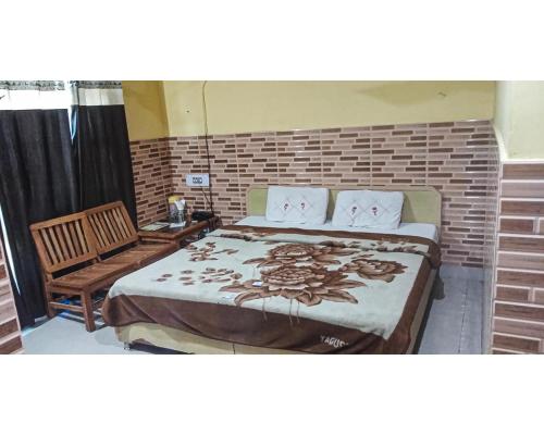 een slaapkamer met een groot bed en een stoel bij Hotel By The Way By WB Inn in Jogindarnagar