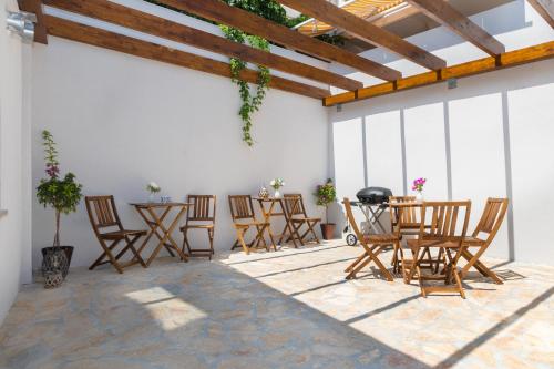 patio con sedie e tavolo con griglia di Luxury apartments Azalea Primošten a Primošten