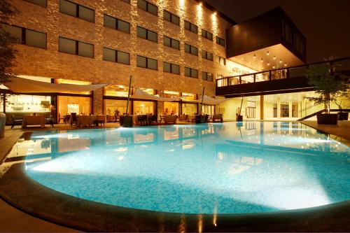 a large swimming pool in front of a building at Devero Hotel BW Signature Collection in Cavenago di Brianza