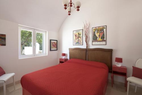 una camera con letto rosso e finestra di le dimore di MaMa a Ceglie Messapica