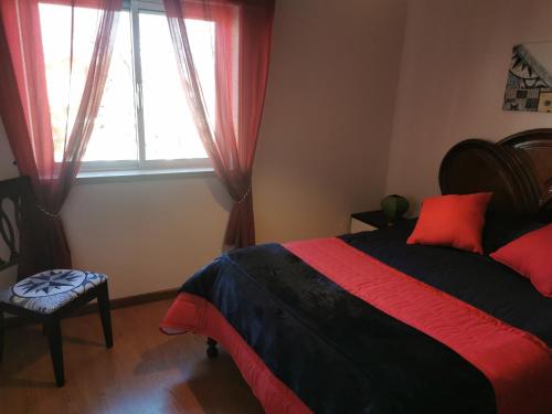 a bedroom with a large bed and a window at Casa do Paço in Almeirim