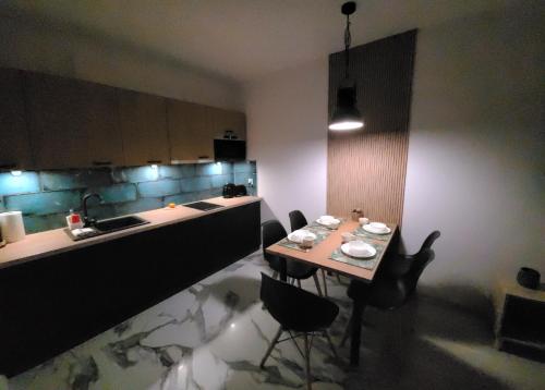 a kitchen with a table with chairs and a sink at Marina Dziwnów Apartment in Dziwnów
