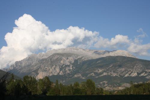 a mountain covered in snow and clouds in the sky at Casa Miranda in Campo