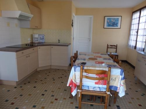 une cuisine avec une table et des chaises et une cuisine avec un évier dans l'établissement Maisonnette calme proche pêche avec jardin et wifi - FR-1-476-2, à LʼAiguillon-sur-Mer