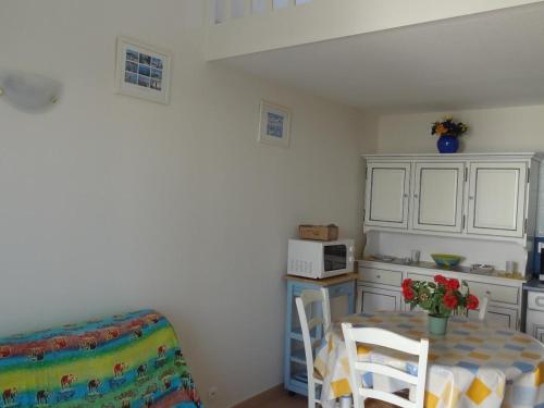 une petite cuisine avec une table et un micro-ondes dans l'établissement Maisonnette avec piscine à 1800m de la plage, idéale pour familles - La Faute-sur-Mer - FR-1-476-35, à La Faute-sur-Mer