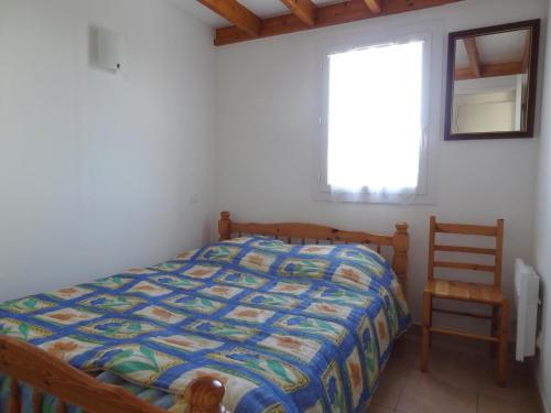 ein Schlafzimmer mit einem Bett, einem Stuhl und einem Fenster in der Unterkunft Maison La Faute-sur-Mer, 2 pièces, 5 personnes - FR-1-476-35 in La Faute-sur-Mer