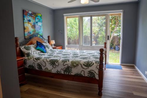 A bed or beds in a room at Cosy 4 Bedroom Holiday Home - Melbourne Airport