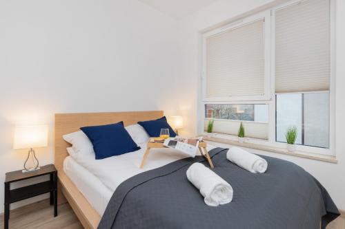 sypialnia z dużym łóżkiem i 2 oknami w obiekcie Nowa Grobla Estate Apartment near Starówka by Renters w Gdańsku