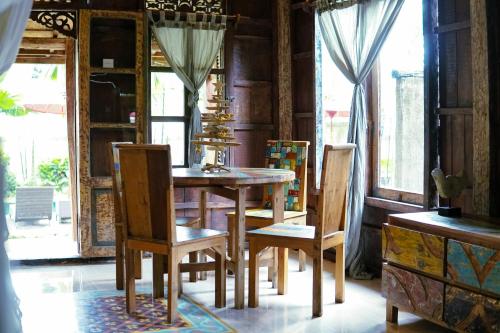 a dining room with a wooden table and chairs at Sentana Villa Ubud in Ubud