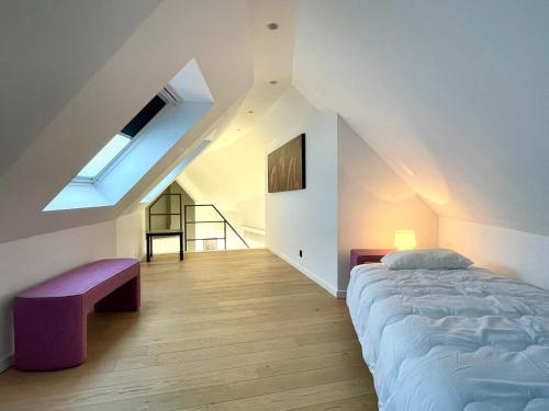 a bedroom with a bed and a bench and a skylight at Exclusive Penthouse in Ghent in Ghent