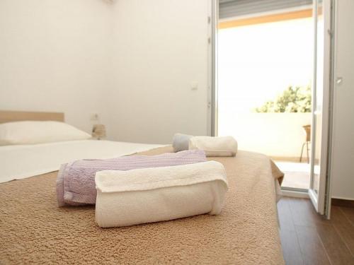 a bedroom with two beds with towels on a rug at Pansion Jurko in Pag