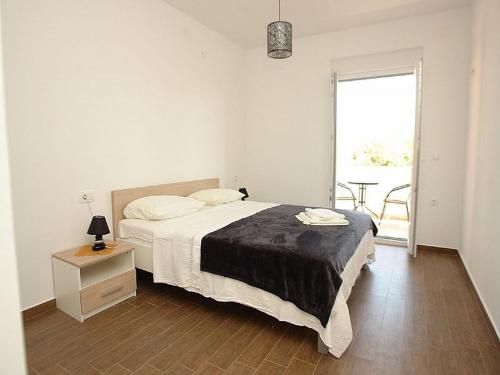 a bedroom with a bed and a table and a window at Pansion Jurko in Pag