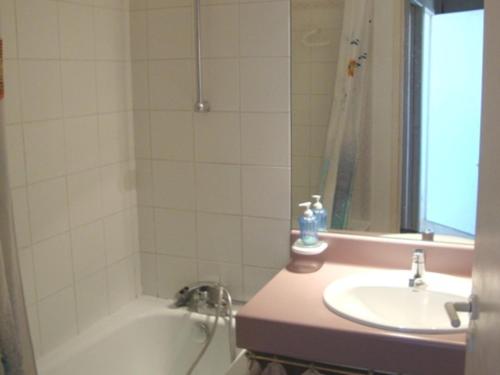une salle de bain avec un lavabo et une baignoire et un lavabo dans l'établissement La Rochelle: Appt 3 pièces, 6 pers, piscine, parking, proche plage - FR-1-551-19, à La Rochelle