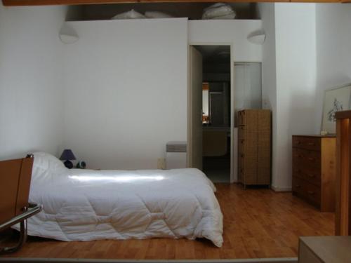 une chambre avec un lit blanc et un parquet dans l'établissement Charmant T2 avec piscine aux Minimes, proche plage - La Rochelle - FR-1-551-48, à La Rochelle