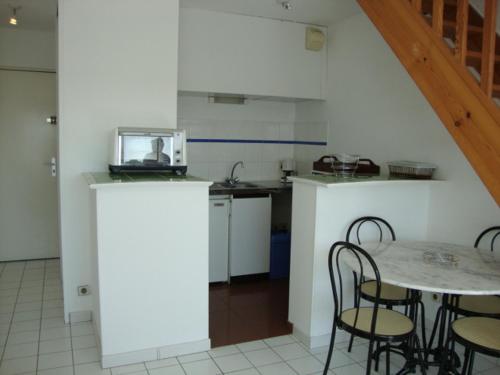 une cuisine avec une table et des chaises dans une pièce dans l'établissement Charmant T2 avec piscine aux Minimes, proche plage - La Rochelle - FR-1-551-48, à La Rochelle
